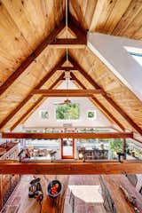 The view from the mezzanine, showcasing the soaring ceilings in the kitchen and dining area.  Photo 8 of 14 in A Wooded Retreat With Two Shingle-Clad Homes Seeks $1.7M in Carmel