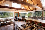 Exposed beams continue in the kitchen, complementing the vaulted, wood-clad ceilings.