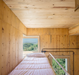 In the lofted sleeping quarter, a passive solar window box frames picturesque views of the surrounding natural park.&nbsp;