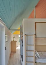 The cabin can comfortably accommodate four adults. A set of bunk beds are positioned on one side of a wall that separates the living room and sleeping quarters.
