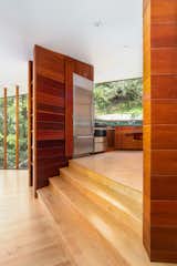 Honey-hued flooring complements the original cedar-clad walls that envelop the kitchen.