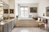 The principal bathroom features an oversized soaking tub that is encased with elegant stone. Cut-out shelving provides additional storage on one wall.  Photo 10 of 12 in A 19th-Century Converted Theater Lists for $2M Near Copenhagen