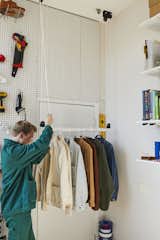 At his Brooklyn apartment, Joshua Skirtich rigged a hanging closet for $45, using a kayak holder and PVC pipe. The system went through a couple of iterations, and there is a "hole graveyard" on the ceiling, he says, along with a stray pulley left over from an earlier version. "I like seeing the progress," says Joshua, who streamlined his wardrobe so it would fit in his new closet.