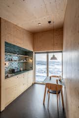 To protect the 226-square-foot structure from extreme weather, the architects relied on charred-pine cladding made using the ancient Japanese method of shou sugi ban. The cabin’s light plywood interior offers a stark contrast to the dark cladding of the exterior. Emerald tiles span the fully equipped kitchenette, adding a playful splash of color.
