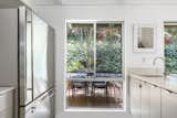 Near the refrigerator, a large window overlooks the home’s private rear patio.