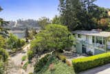 An exterior view of the property showcases its verdant landscaping and close proximity to the water.