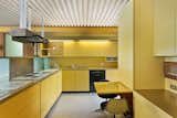 The kitchen maintains its original charm with yellow Formica cabinetry and a built-in radio.