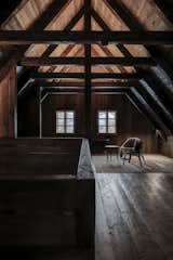 Upstairs, a loft awaits with picture windows that overlook the alpine landscape. The deliberately placed lighting enhances the moody ambience of the space.