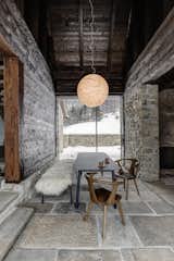 The dining area is located in what used to be the passageway between the house and the barn. Lighting designer Davide Groppi’s Moon luminaire hangs above the table near tall, sliding glass doors that extend the space to the enclosed yard.