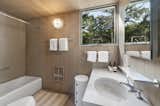 Timber continues into the primary bath, which features a large soaking tub and elevated views.