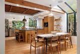 An exposed wooden beam serves as a subtle divider between the open dining area and kitchen.