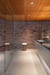 A brick-clad wall in the principal bathroom is topped with a protective coat of tiny, glossy beads.