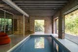 An indoor pool sits between the open-air patio and home gym at the rear of the home.