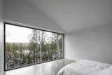 Bedroom, Ceiling Lighting, Bed, and Concrete Floor  Photo 13 of 17 in A Cathedral-Esque Lake Home Rises in the Quebec Countryside