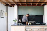 Derek and Jean enjoy cooking, and at times, they’ll use vegetables they grow on a shared garden plot not far from their house. A custom timber kitchen island features a matching set of stools made locally by James Mudge, and a countertop in dark stone echoes the backsplash.