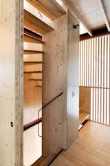 A staircase winds up through the center of the house. Its structural spine is made of cross-laminated timber, while the screen that encloses it is made from slats of South African pine. “The timber screen separates the stair from the surrounding space but still allows glimpses through,” says Douglas. “It recalls Japanese screens, especially at night when it lights up like a lantern.”