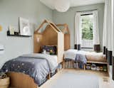 In the kids’ room, a pendant from Cedar &amp; Moss hangs above custom gabled beds with integrated lighting. The walls are painted Tranquility by Benjamin Moore.