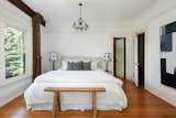Upstairs, the primary bedroom features ornate wooden accents that frame the walls and doorway.