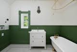Green hues continue into one of the upper-level bathrooms, which features another clawfoot tub.