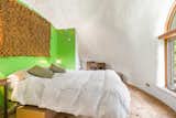 Vibrant green hues extend a warm welcome to the bedroom located on the upper level.