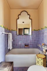 Another one of the bathrooms is dressed in cheerful purple tile—original to the space.