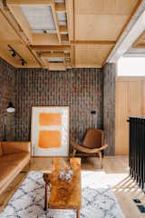 The contemporary wood panelling continues into the top-level lounge space, complementing the surrounding brick walls and oak hardwood flooring.
