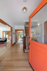 A bright orange door extends a warm welcome while adding a fun pop of color to the home's exterior white facade.  Photo 2 of 21 in The Oakland Home Where “Mother” of Mother’s Cookies Once Lived Asks $1.4M