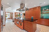 "I always wanted a bright orange stove as the centerpiece of a chef’s kitchen," states Ryan. The top-of-the-line BlueStar appliance contrasts with the surrounding custom cabinetry.
