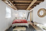 Wooden accents pop against the stark white walls in the bedroom.&nbsp;