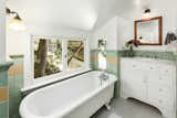 The hallway bathroom features an antique clawfoot tub and original green tiles.