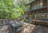 A spacious deck shaded by a towering Liquidambar tree provides an idyllic spot for outdoor eating and entertaining just off the kitchen.
