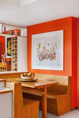 Dining Room, Bench, Table, and Shelves In the dining room, a tabletop ceramic by Marlene Steyn is one of many South African artworks in the colorful home.  Photo 4 of 11 in Fashion Designer Lezanne Viviers’s Johannesburg Digs Double as a Studio and Concept Store