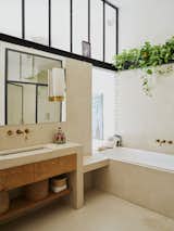 The adjoining bathroom gets indirect daylight via openings in the brick wall and a transom window.