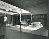 The entry court, partially roofed with screening, can be opened to the living areas through the full-height glass doors seen to the left. The front door is at center-left, and behind the stone wall are the primary bedroom suite and another bedroom.  Photo 5 of 11 in Travel Back in Time to William F. Cody’s Now-Razed Desert Modern