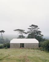 Architects Tom Powell and Sam Nelson rehabilitated a dilapidated barn in the Devonshire countryside of southwest England for an older couple who just needed living space for themselves and the occasional guest.The aluminum roof is a material that recalls the typical use of corrugated metal on agricultural buildings, yet it subtly contrasts with the historic form. "It’s not quite what you’d use on a normal barn," says Powell.