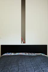 A frameless piece of glass separates the main bedroom from the stairwell, opening up sight lines on the second floor.