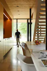 A Formica-clad island extends from the dining area to the office and is lined with swivel chairs from Muuto.