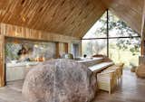 Architect Lee de Wit worked with his relatives to create a family getaway in his grandfather’s old farmhouse northwest of Johannesburg. The original barn became the footprint for the renovated kitchen and living space. The kitchen island is anchored by massive boulders sourced on-site, and the walls and ceiling are clad with wood from fallen logs found on the property.  "We gave ourselves the task of reusing every available material possible," says the architect.