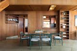 A partition with intentionally placed openings demarcates the dining area from the kitchen.