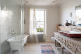 The en suite bathroom includes a frameless shower, freestanding tub, and antique vanity.