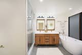 The bathroom included in the primary suite presents a large shower and oversized soaking tub.  Photo 9 of 13 in A Restored Midcentury Wrapped Around a Reflecting Pool Lists for $1.39M in Sacramento, CA