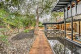 A wooden walkway wraps around the home, connecting the zen garden at the side of the residence to the backyard.
