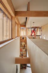 Blandine asked Égoïne to create handholds along each bookshelf to allow her boys—and herself—to climb from the ground floor to the second story. A pull-down ladder leads to the uppermost level, a mezzanine nestled beneath the roof.  Photo 1 of 392 in Small houses by lore.pekrul@gmail.com from An Eccentric Facade Turns Heads at This House Outside Paris