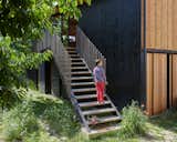 The couple's son, Nathan, outside the home, which is partially covered in wood cladding from Birka DC.
