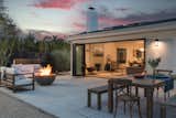 A cozy outdoor seating area with a fire pit connects to the home’s interior via folding glass doors.