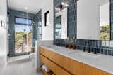 A large window in the bathroom shower enhances the indoor-outdoor experience that is central to Southern California living.