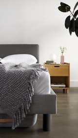 The upholstered Circa bed in Heather Charcoal and a Prospect nightstand in oak.