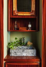 Hugo designed the Breccia Parma stone stink in the bathroom, which is combined with a wicker mirror, mahogany furniture, and an onyx soap holder from Mexico.