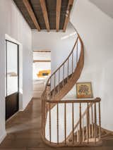 A winding staircase leads from the ground level to the first floor, which houses two bedrooms and one bath.