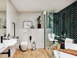 Emerald-green herringbone tile adds color to the roll-in shower of British TV presenter Sophie Morgan.